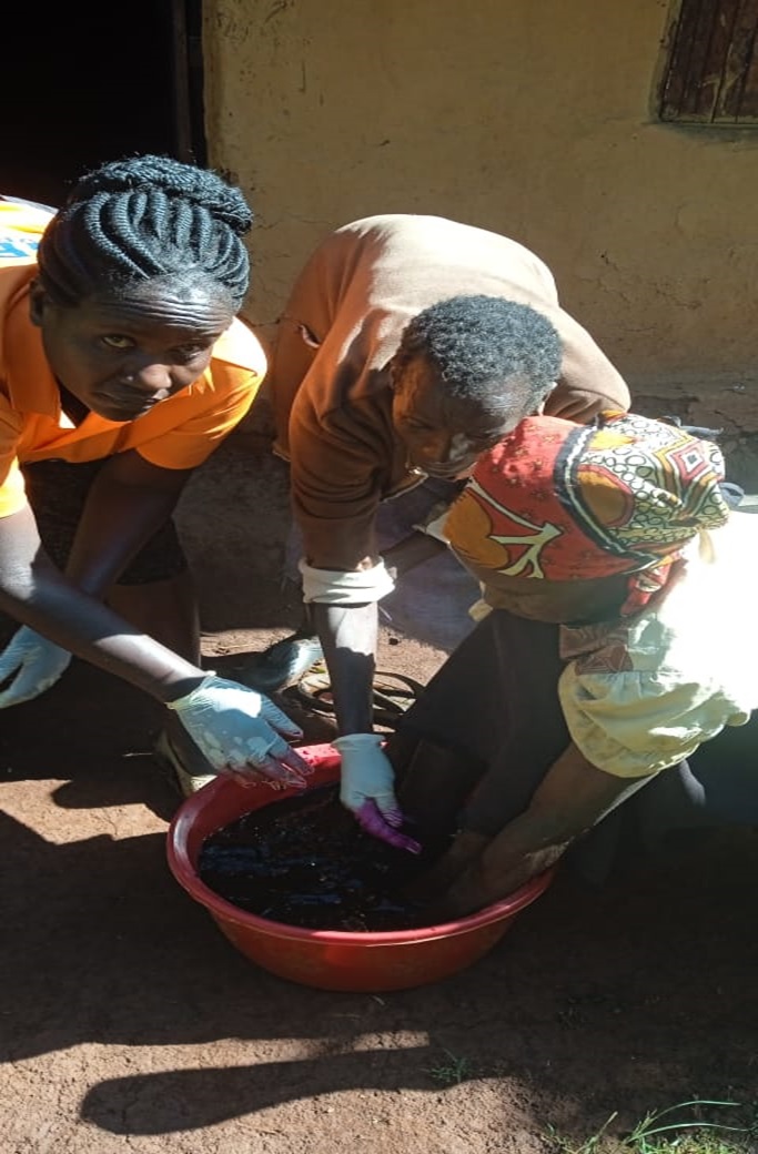 A palliative care patient assisted in washing her feet affected by jiggers.